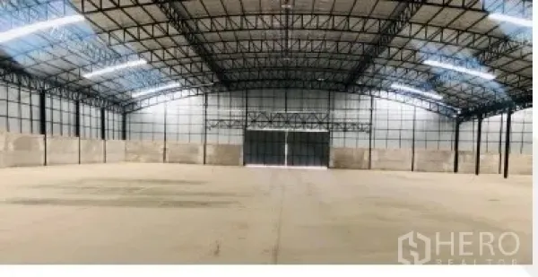 货栈 出租在Chon Buri - 仓库内部开放式空间，钢结构高屋架、采光天窗和大型推拉门。