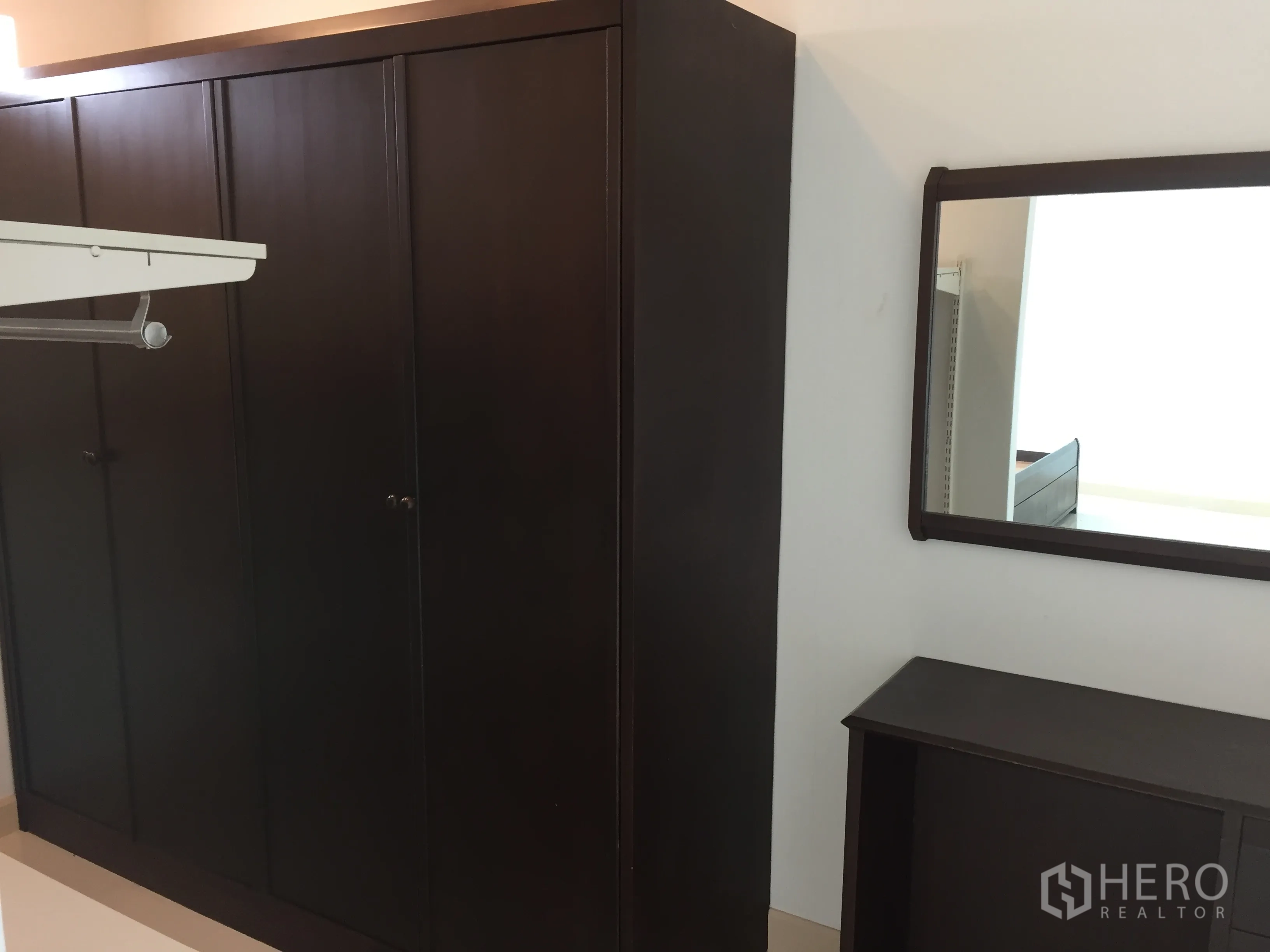 ทาวน์เฮาส์ ให้เช่าในDin Daeng, Bangkok - ตู้เสื้อผ้าไม้สีเข้มขนาดใหญ่พร้อมกระจกเงาและโต๊ะเครื่องแป้งแบบเรียบง่าย