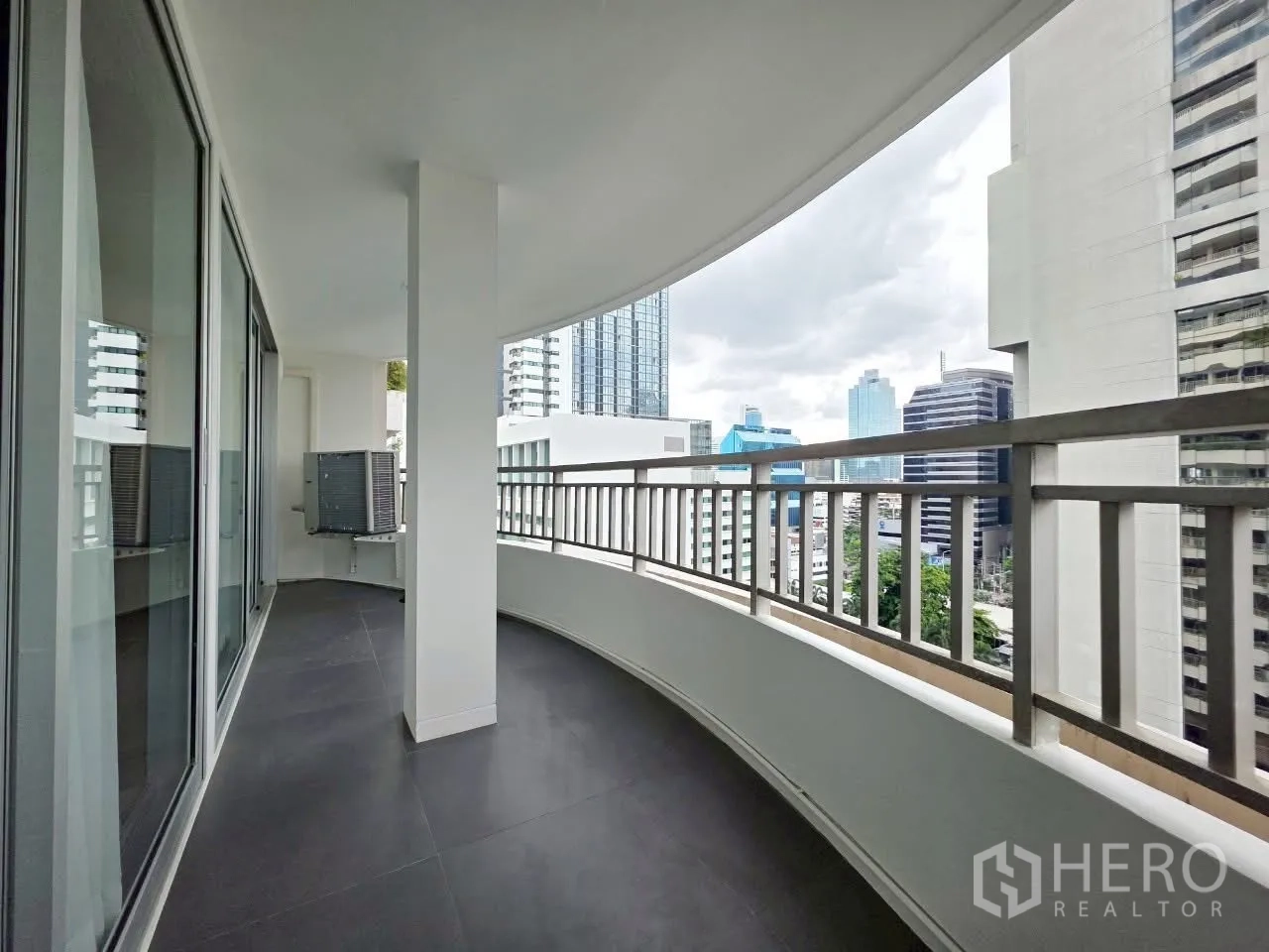 Condominium for rent in Sathon, Bangkok - Spacious curved balcony of a high-rise condo overlooking the Sathon skyline.