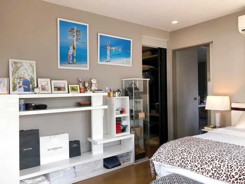 公寓 出租在Bang Rak, Bangkok - 卧室配开放式收纳与步入式衣帽间，床边陈列柜。