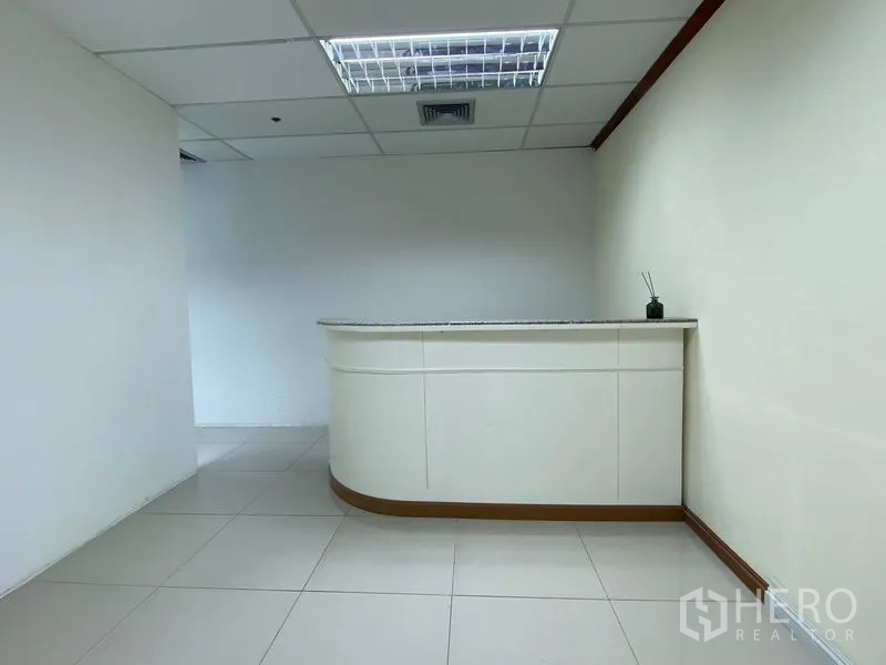Office Space for rent in Huai Khwang, Bangkok - Reception counter in a bright tiled office lobby with drop ceiling lighting.