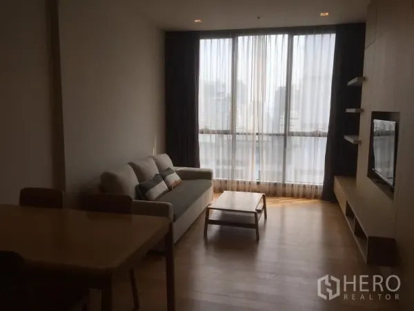 คอนโด ให้เช่าหรือขายในWatthana, Bangkok - ห้องนั่งเล่นมีโซฟา ชั้นวางทีวี โต๊ะกลาง และหน้าต่างบานใหญ่ชมวิวเมือง