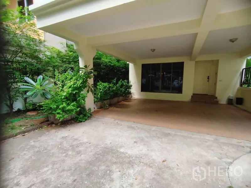 บ้าน ให้เช่าในWatthana, Bangkok - โรงจอดรถมีหลังคาและทางเข้าบ้าน ล้อมด้วยต้นไม้