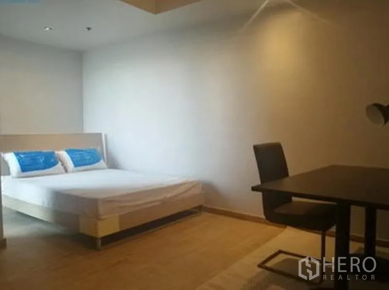 Condominium for sale in Sathon, Bangkok - Spacious bedroom with double bed and a work desk and chair.