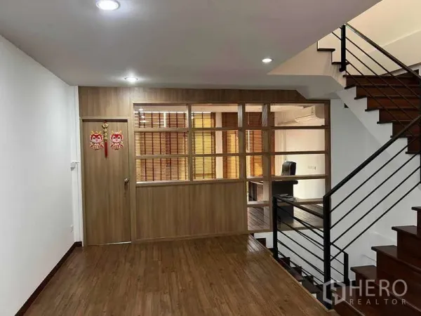 Home Office for rent in Bueng Kum, Bangkok - Upper floor landing with wood flooring, glass-partitioned office and metal staircase railing.