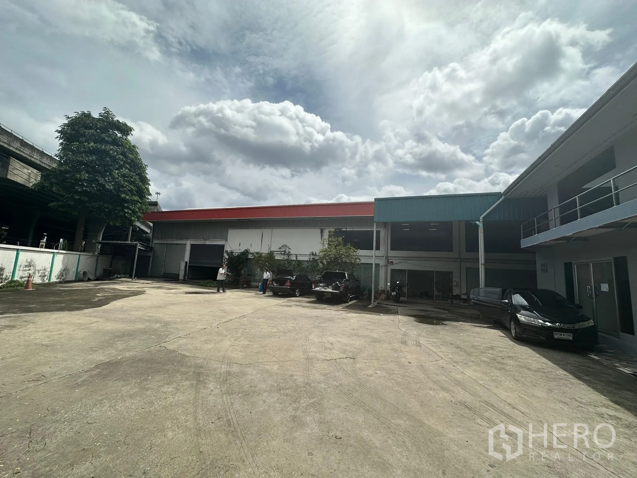 Warehouse for rent in Huai Khwang, Bangkok - Spacious concrete courtyard with warehouse bays and on-site parking.