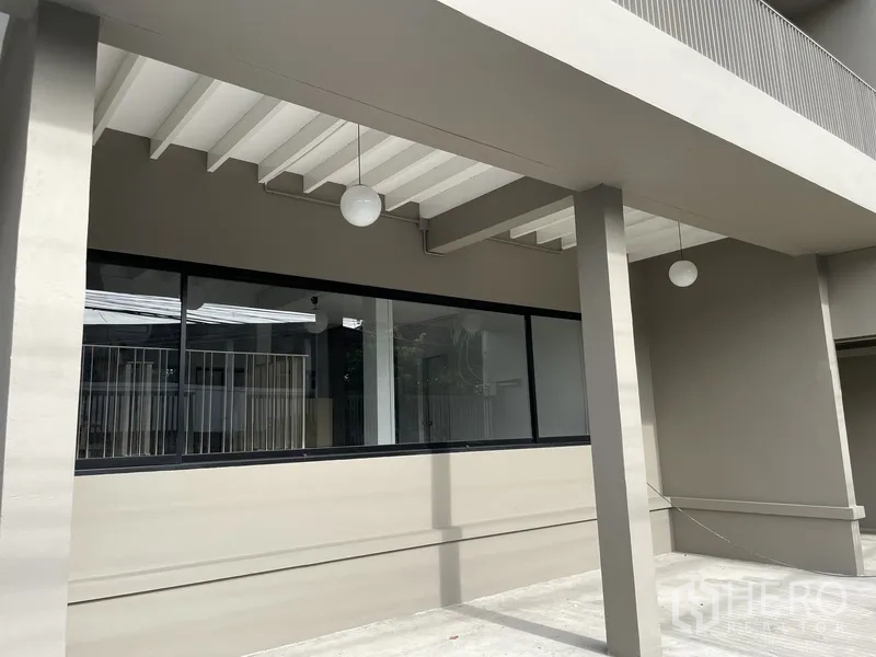 สำนักงานที่บ้าน ให้เช่าในKhlong Toei, Bangkok - ระเบียงชั้นล่างใต้ชายคาพร้อมโคมไฟและหน้าต่างบานยาว