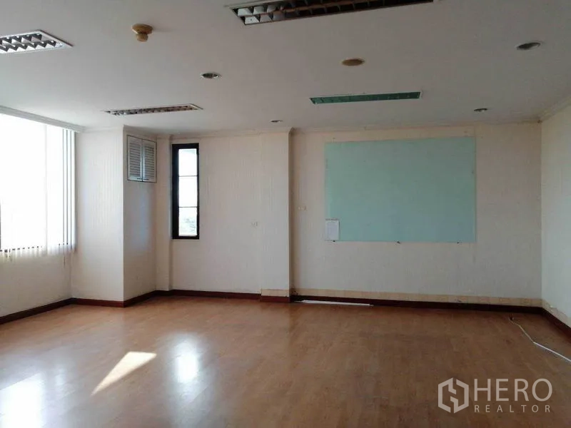 Office Space for rent in Bueng Kum, Bangkok - Bright corner office with large windows and a wall‑mounted whiteboard.