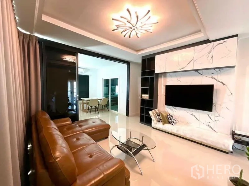 บ้าน ขายในBang Sao Thong, Samut Prakan - พื้นที่นั่งเล่นผนังทีวีลายหินอ่อน พร้อมชั้นบิวท์อินและประตูกระจกบานเลื่อน