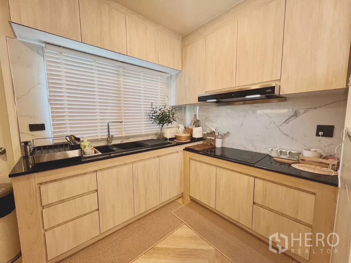 Detached House for rent in Bang Phli, Samut Prakan - Built-in L-shaped kitchen with marble backsplash, black countertops and a window.