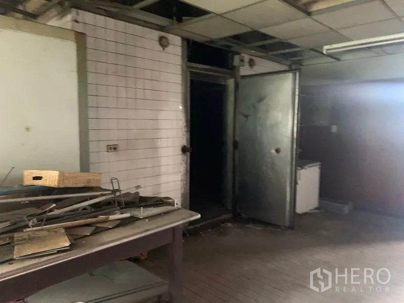 อาคารพาณิชย์ ให้เช่าในWatthana, Bangkok - ห้องเตรียมอาหารหลังบ้าน ผนังกระเบื้องสีขาว ประตู่โลหะ และโต๊ะทำงาน