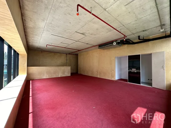 พื้นที่ขายปลีก ให้เช่าในWatthana, Bangkok - พื้นที่ชั้นลอยกว้าง พรมสีแดง ประตูบานเลื่อน และท่อระบบโชว์บนเพดาน