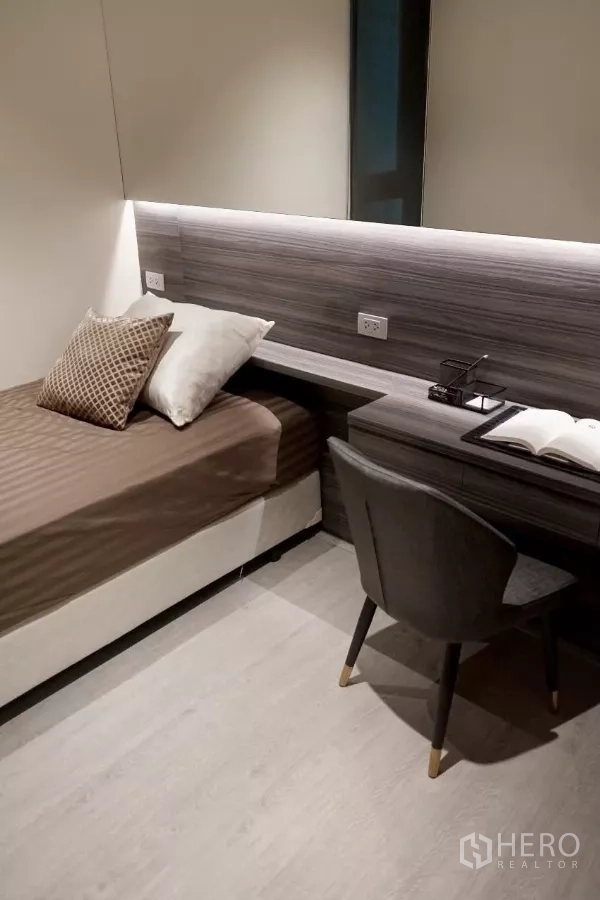 Condominium for rent in Watthana, Bangkok - Second bedroom with single bed and built‑in study desk under soft strip lighting.