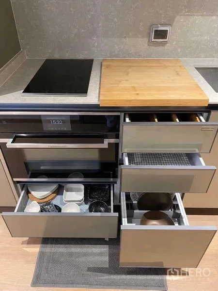 公寓 出租在Watthana, Bangkok - 厨房抽屉打开，展示餐具与锅具的收纳