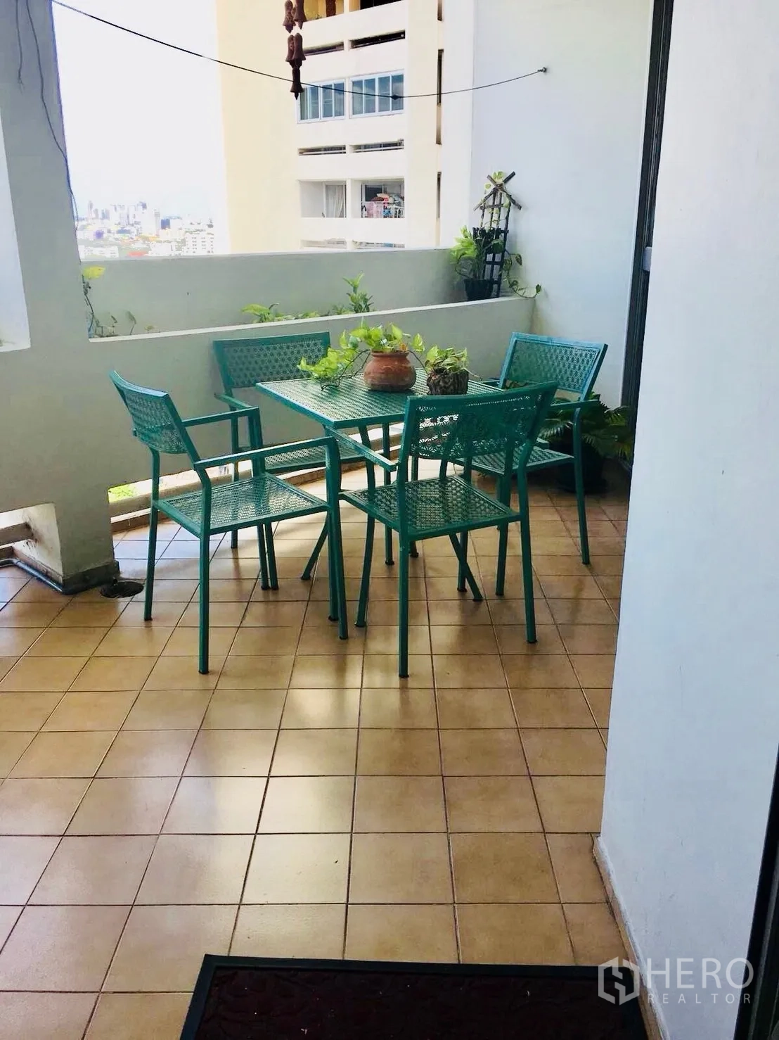 公寓 for rent in Watthana, Bangkok - 阳台摆放户外餐桌椅，可见城市景观与绿植。