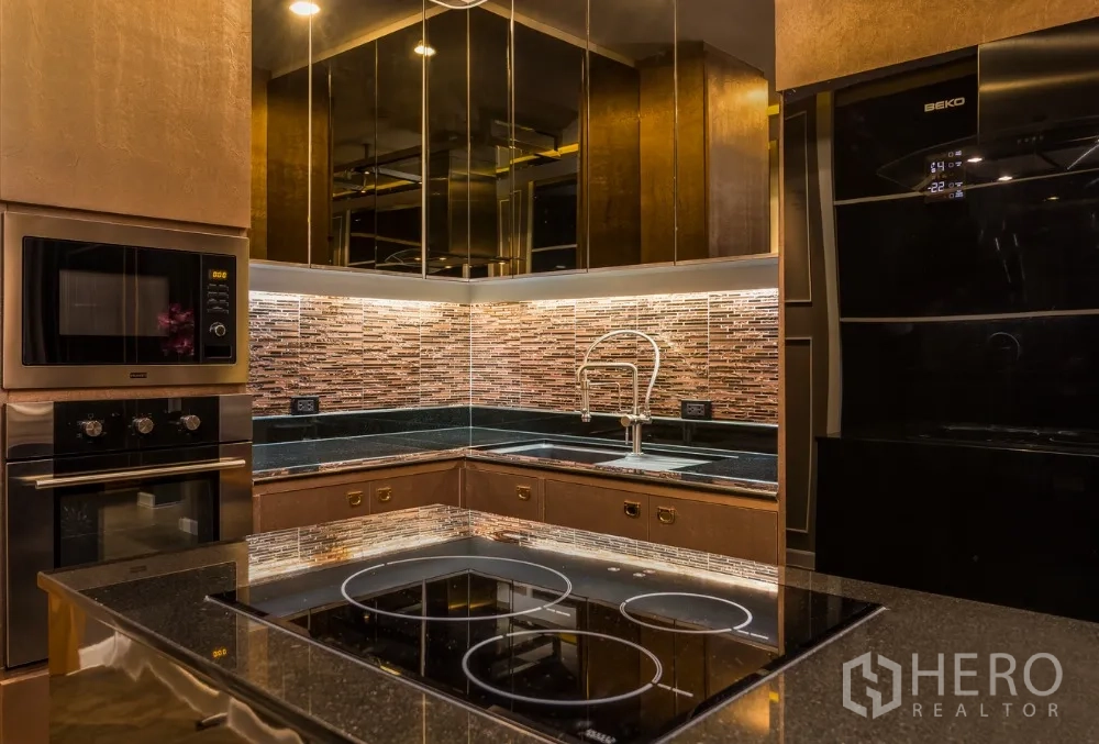 公寓 出租在Ratchathewi, Bangkok - 开放式厨房，石材台面、岛台电磁炉与镜面橱柜。