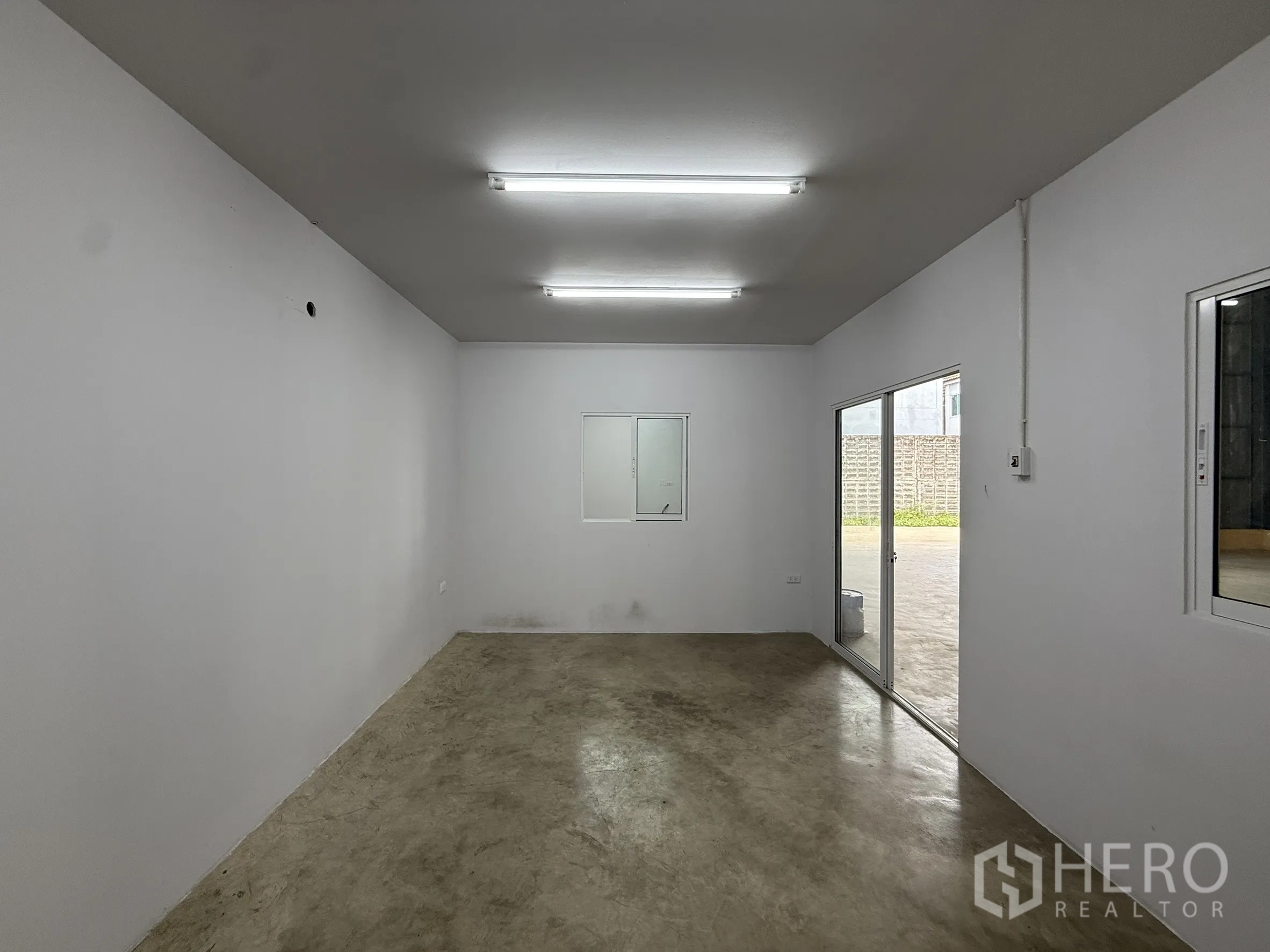 Warehouse for rent in Wang Thonglang, Bangkok - Office room with fluorescent lighting, window and sliding glass door.