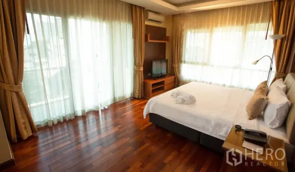 อพาร์ทเมนท์ ให้เช่าในKhlong Toei, Bangkok - ห้องนอนมุมห้อง หน้าต่างบานใหญ่ พื้นไม้ ทีวี และเครื่องปรับอากาศ ในอพาร์ทเมนท์คลองเตย