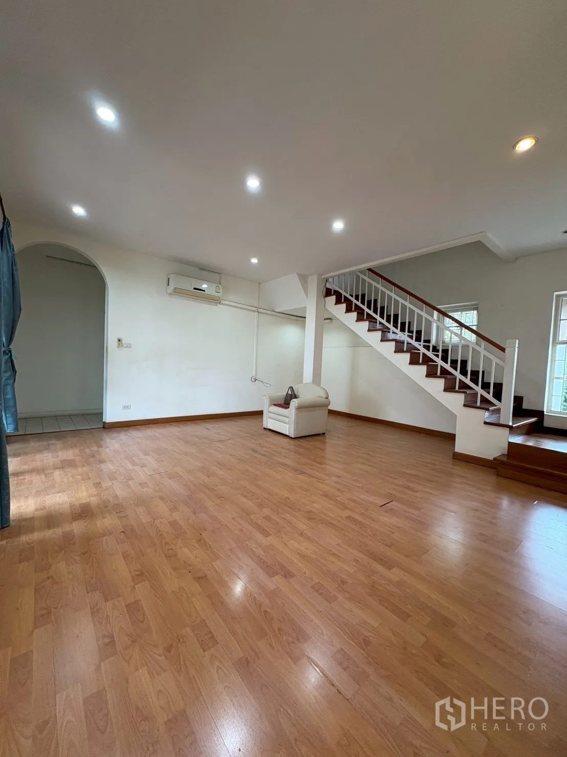 บ้าน ขายในPhra Khanong, Bangkok - ห้องรับแขกกว้าง พื้นไม้ บันได และไฟสปอตไลท์เพดาน