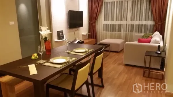 คอนโด ให้เช่าในKhlong San, Bangkok - ห้องนั่งเล่นและรับประทานอาหารแบบเปิด พื้นไม้ โซฟา ผนังทีวี และหน้าต่างผ้าม่านขนาดใหญ่