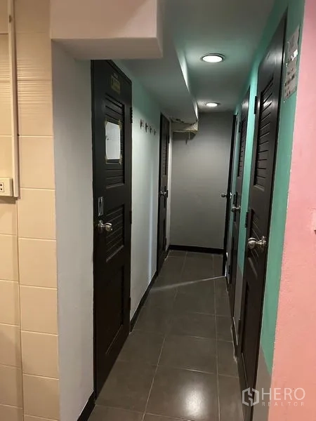 Home Office for rent or sale in Khlong Toei, Bangkok - Tiled corridor with recessed lights and several dark wood doors leading to separate rooms.