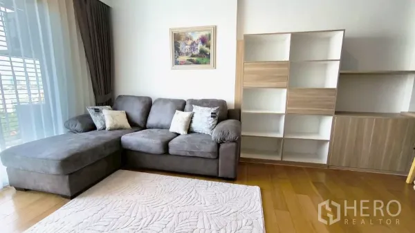 คอนโด ให้เช่าในWatthana, Bangkok - ห้องนั่งเล่นมีโซฟา L สีเทา ตู้บิลท์อิน และหน้าต่างสูงเต็มบาน