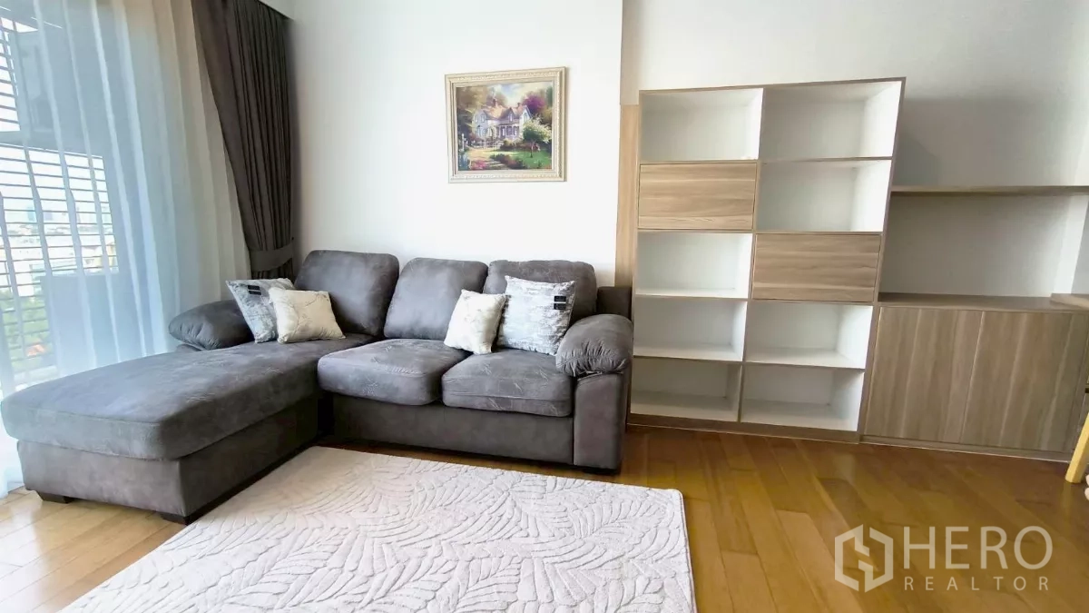 คอนโด ให้เช่าในWatthana, Bangkok - ห้องนั่งเล่นมีโซฟา L สีเทา ตู้บิลท์อิน และหน้าต่างสูงเต็มบาน