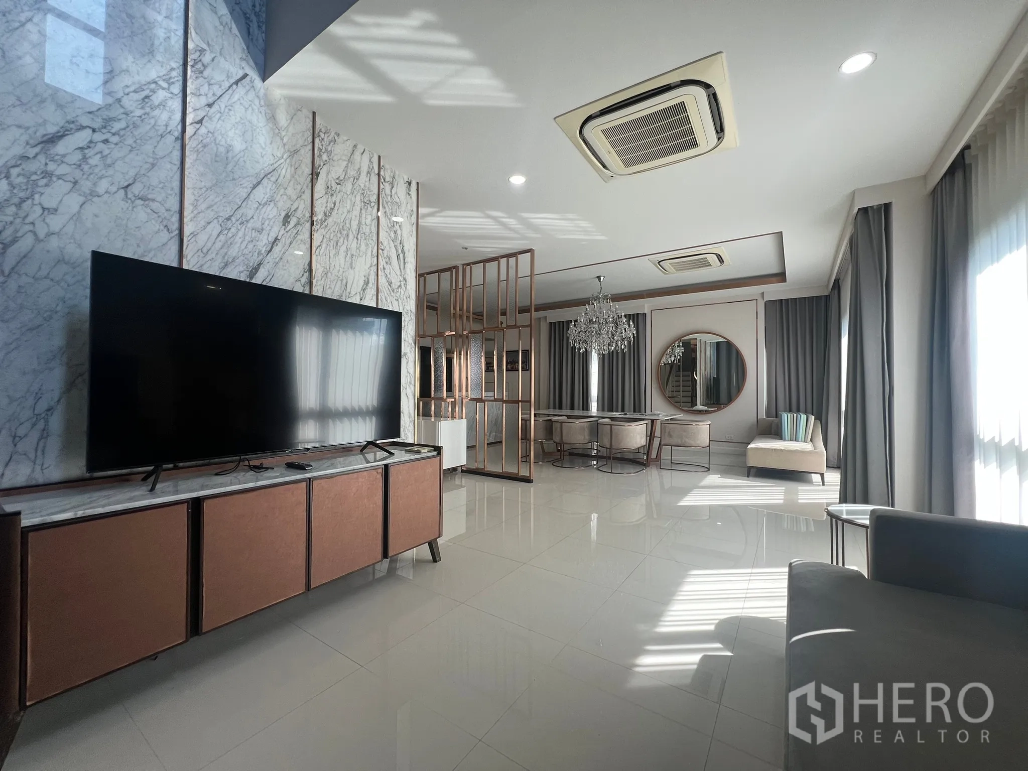 บ้าน ให้เช่าหรือขายในPrawet, Bangkok - โถงรับแขกกว้างเชื่อมพื้นที่ทานอาหาร ทีวีจอใหญ่ ผนังหินอ่อน และไฟฝ้าซ่อนไฟ