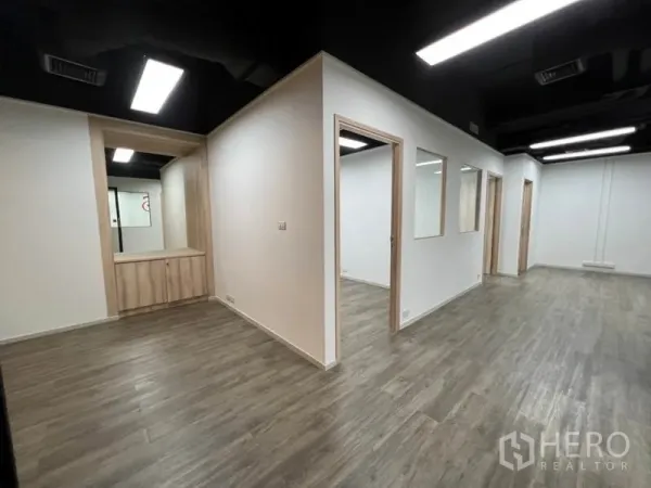 办公空间 出租在Khlong Toei, Bangkok - 室内分隔多间房，带接待台与内置柜，木纹地板