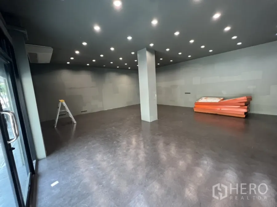 店屋 出租在Phra Khanong, Bangkok - 一层开阔店面，深色地坪、中央立柱与整排嵌入式筒灯