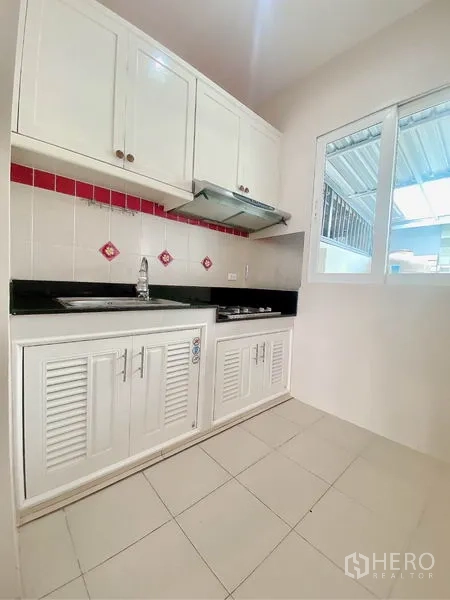 ทาวน์เฮาส์ ให้เช่าในPrawet, Bangkok - ครัวบิวท์อินสีขาว มีตู้ลอย เตา ฮูด และท็อปหินแกรนิตสีดำ