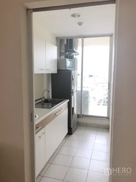 คอนโด ให้เช่าในWatthana, Bangkok - ครัวปิดตู้บิวท์อินโทนขาว พร้อมซิงก์ ตู้เย็น และประตูกระจกออกสู่ระเบียงซักล้าง