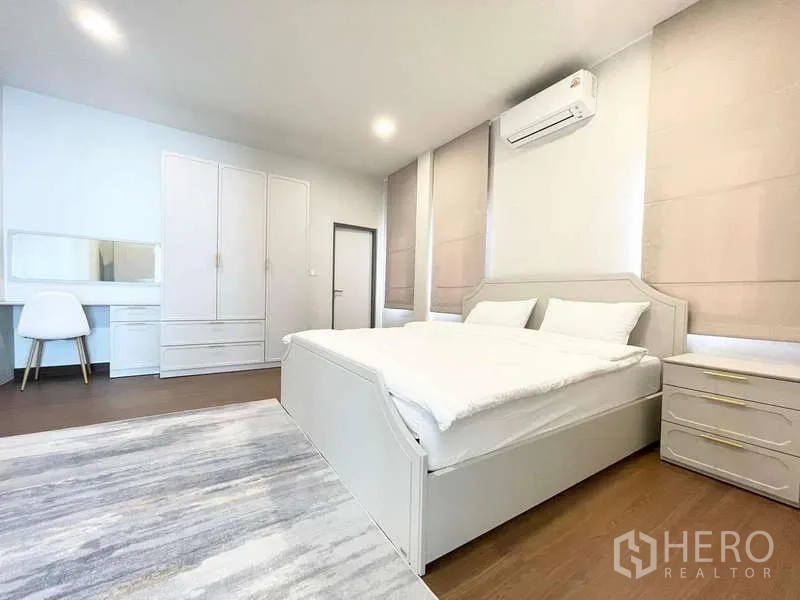Detached House for rent in Bang Phli, Samut Prakan - Bedroom with air conditioner, wardrobe and bedside tables over a soft rug.