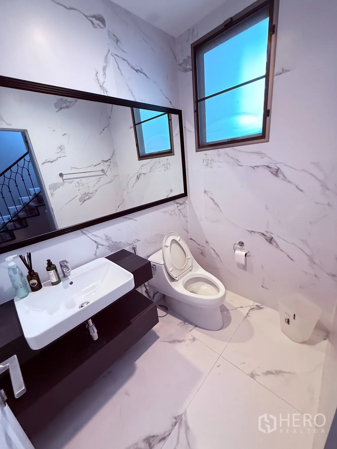 บ้านเดี่ยว for rent or sale in Prawet, Bangkok - ห้องน้ำผนังลายหินอ่อน อ่างล้างหน้า กระจกบานยาว โถสุขภัณฑ์ และหน้าต่าง.