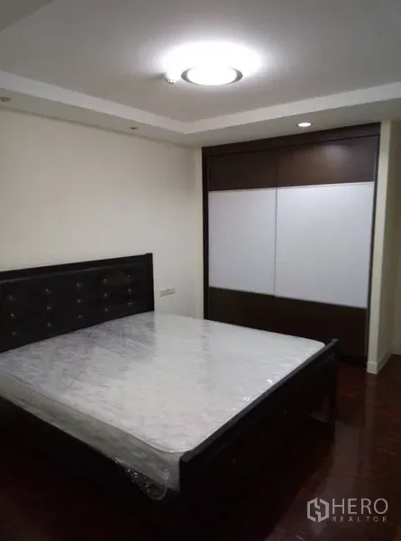 คอนโด ให้เช่าในWatthana, Bangkok - ห้องนอนหลักพร้อมเตียงขนาดใหญ่และตู้เสื้อผ้าบานเลื่อน โทนสีเรียบสงบ