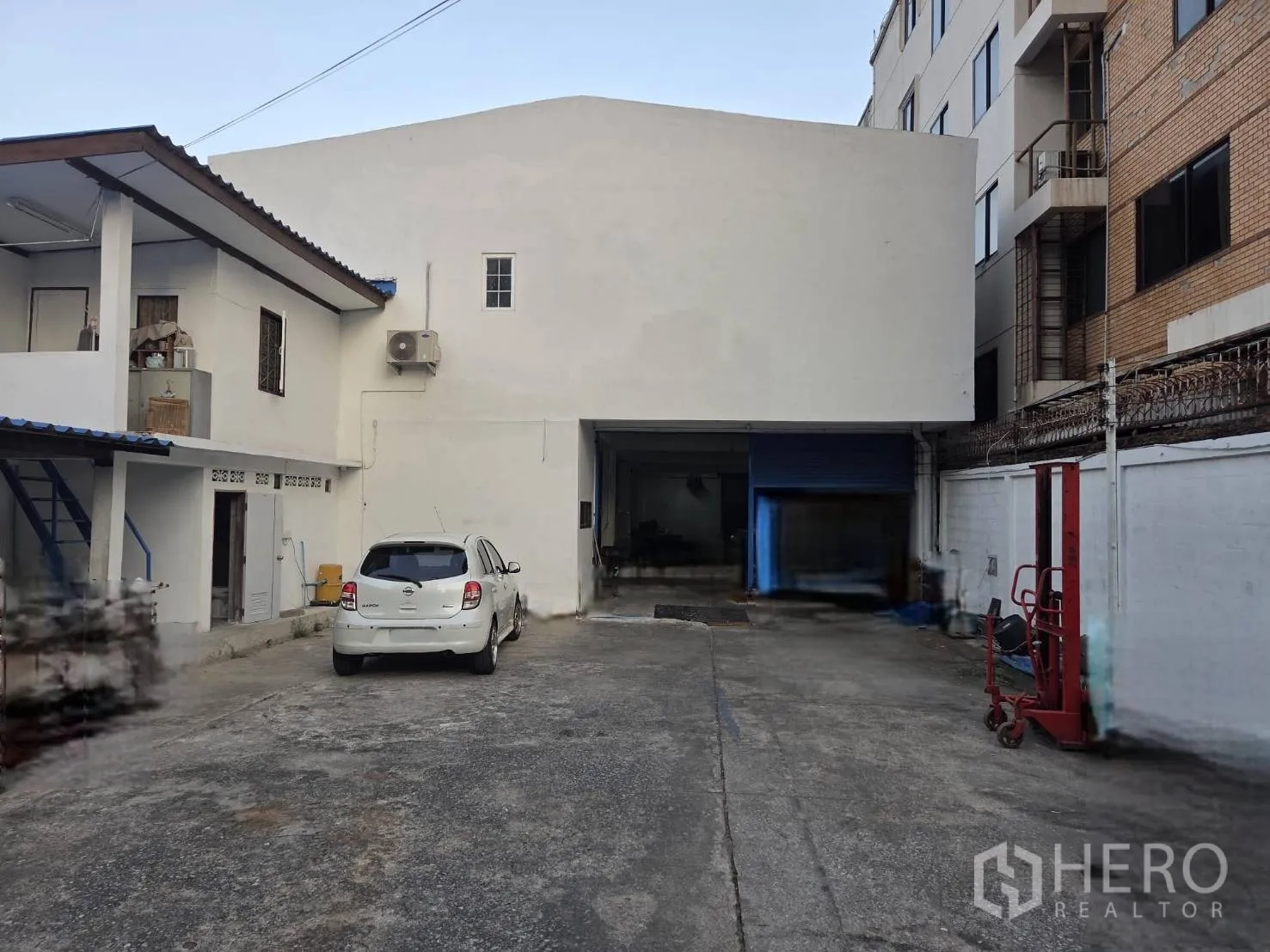 仓库 for rent in Ratchathewi, Bangkok - 仓库外观带私用前院停车区与卷帘装卸门，旁有小型办公附楼。