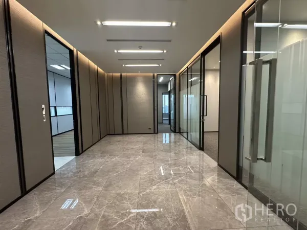 办公空间 出租在Watthana, Bangkok - 大理石地面的走廊，玻璃隔间与嵌入式灯光的高端办公区。
