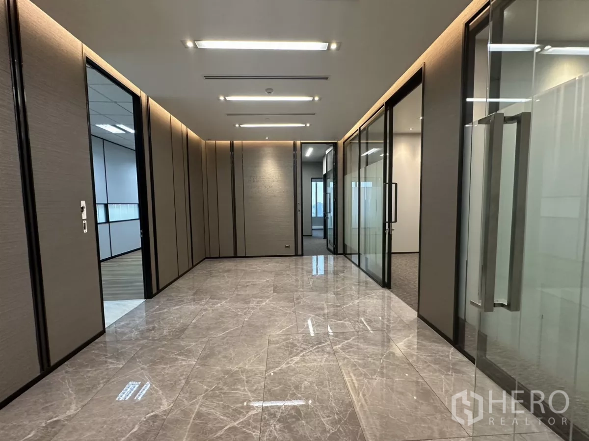 办公空间 出租在Watthana, Bangkok - 大理石地面的走廊，玻璃隔间与嵌入式灯光的高端办公区。