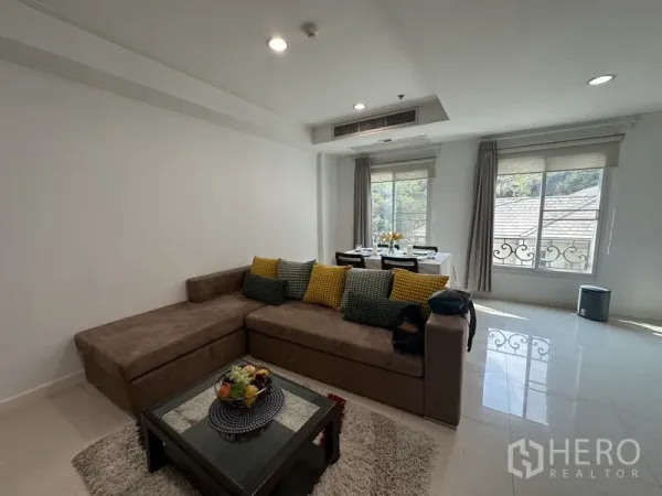 公寓 出租 - 开放式客厅，转角沙发与充足采光，旁侧为餐桌与大窗