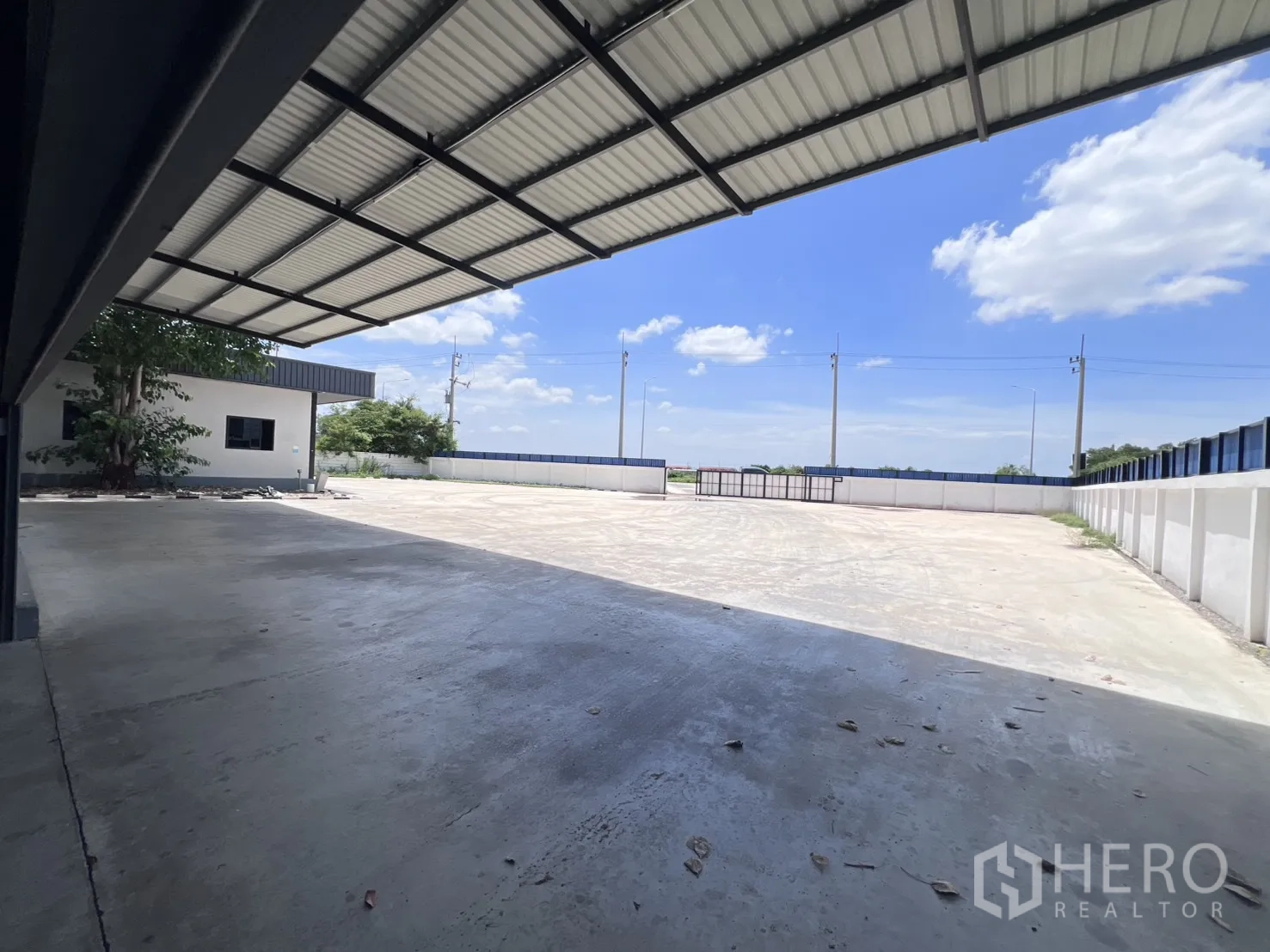 Warehouse for rent in Mueang Samut Sakhon, Samut Sakhon - Covered loading dock looking out to the paved yard and site gates.