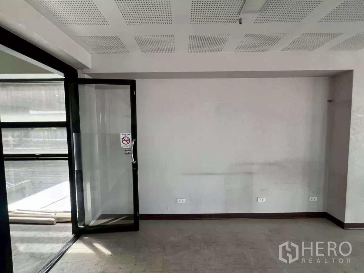 อาคารพาณิชย์ ให้เช่าในHuai Khwang, Bangkok - พื้นที่ออฟฟิศสว่าง มีประตูกระจกออกสู่วงกบหน้าต่างและฝ้าอะคูสติก.