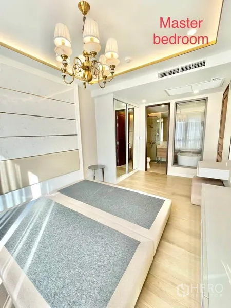 Condominium for sale in Huai Khwang, Bangkok - Master bedroom with chandelier, built-in wardrobe and ensuite bathroom.