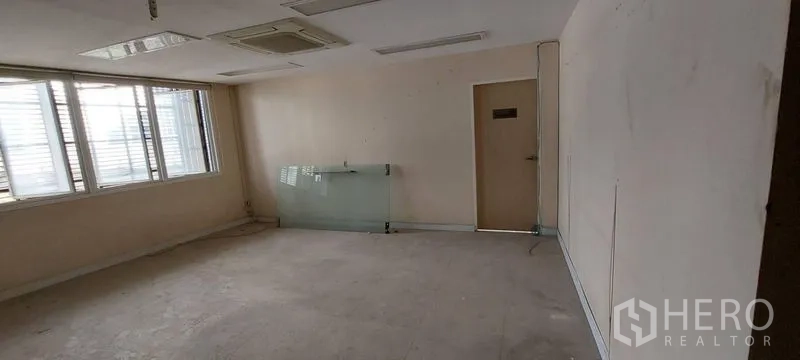 Shophouse for sale - Bright office space with windows and interior door.