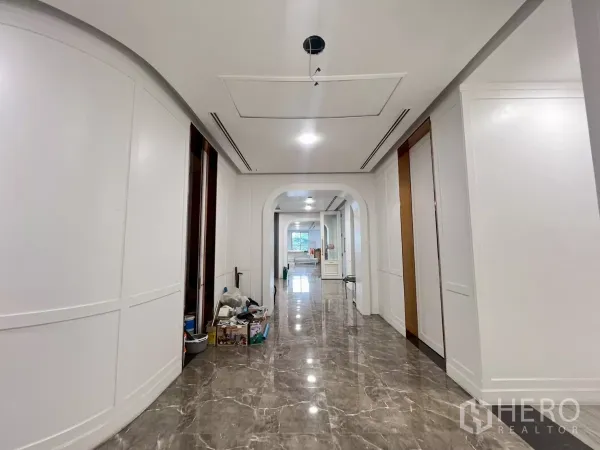 零售空间 出租在Watthana, Bangkok - 明亮走廊，白色墙板、拱形门洞与光亮大理石地面