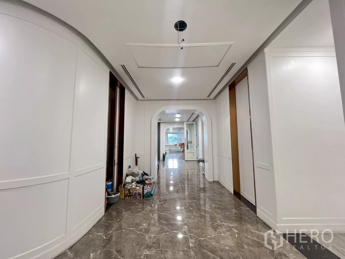 零售空间 出租在Watthana, Bangkok - 明亮走廊，白色墙板、拱形门洞与光亮大理石地面