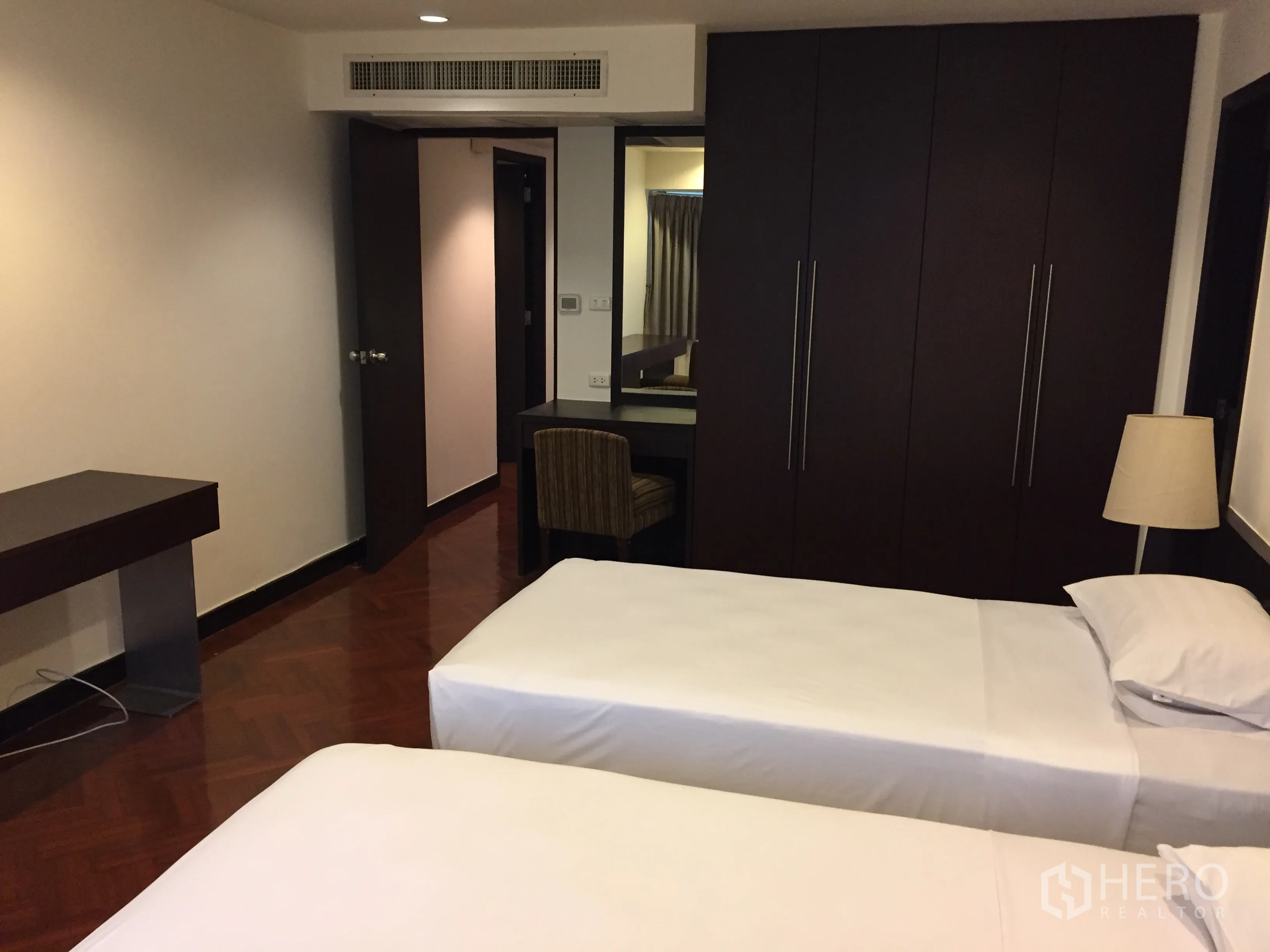 Condominium for rent in Watthana, Bangkok - Twin-bed guest room with built-in wardrobe and study desk.