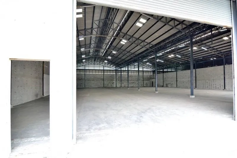 货栈 出租在Phra Pradaeng, Samut Prakan - 从卷闸门望向仓库内部，开放式无柱布局与照明。