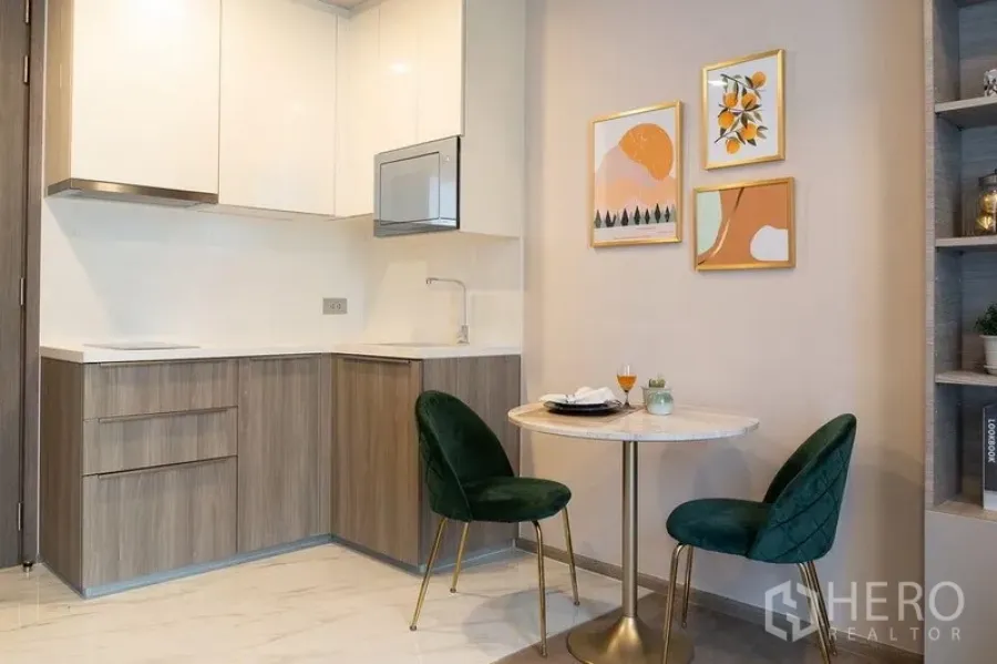 คอนโด ให้เช่าในWatthana, Bangkok - ครัวรูปตัวแอลขนาดกะทัดรัดและมุมทานอาหารสองที่นั่งพร้อมภาพตกแต่งผนัง