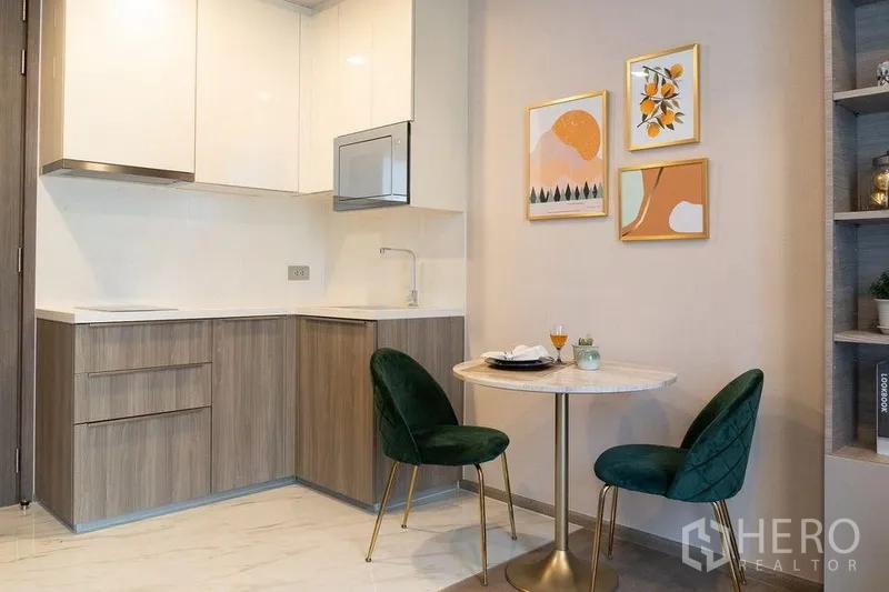 คอนโด ให้เช่าในWatthana, Bangkok - ครัวรูปตัวแอลขนาดกะทัดรัดและมุมทานอาหารสองที่นั่งพร้อมภาพตกแต่งผนัง