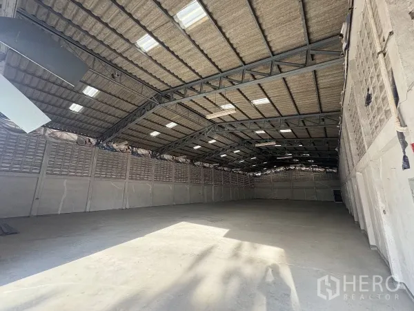 Warehouse for rent in Khlong Toei, Bangkok - Spacious warehouse interior with high steel-truss roof, skylights and concrete floor.